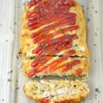Turkey Meatloaf with tomato sauce on a wood cutting board