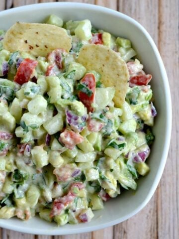 A white bowl of cucumber avocado salsa