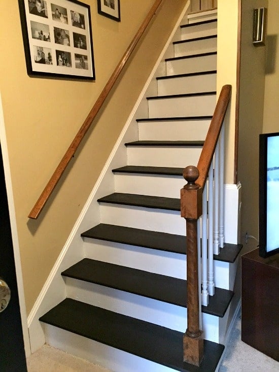 A wood staircase painted with black treads and white risers