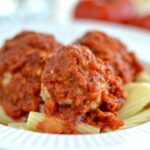 Meatballs over penne pasta topped with marinara sauce