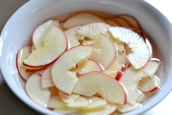 Sliced apples in a bowl of water 