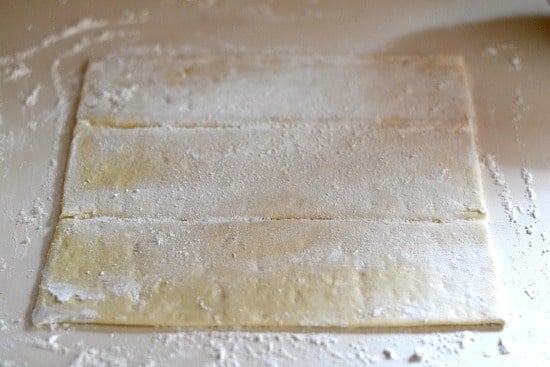 Floured puffed pastry sheets laying flat on a counter 