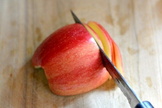 Slicing apples with a knife on a cutting board