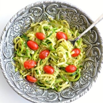 Pesto Zucchini Noodles with cherry tomatoes in a big silver serving bowl