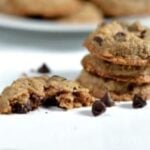 Three Oatmeal Chocolate Chip Cookies stacked on a white table with a plate