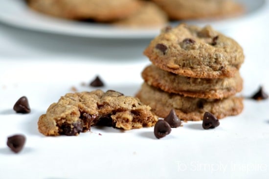  Oatmeal Chocolate Chip Cookies on a white table surrounded by chocolate chips