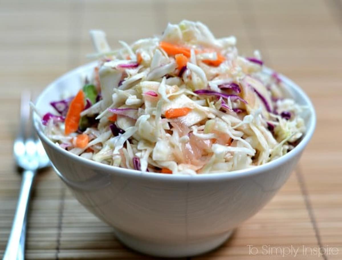 Ginger Sesame Slaw recipe in a white bowl on a bamboo placemat