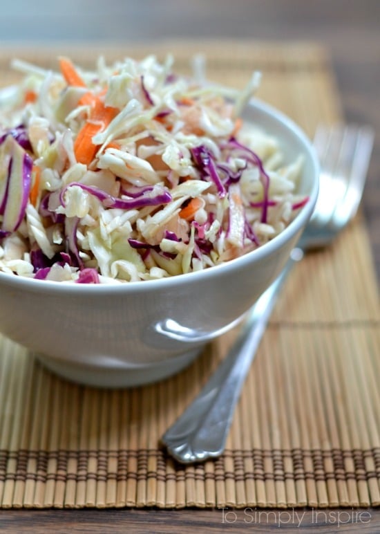 Closeup of Ginger Sesame Slaw recipe in a white bowl on a bamboo placemat