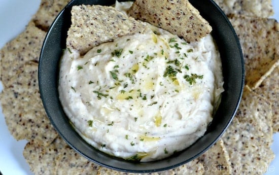 White Bean Dip recipe in a black bowl surrounded by chips