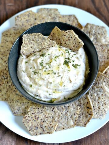 White Bean Dip Recipe in a bowl surrounded by chips with text overlay