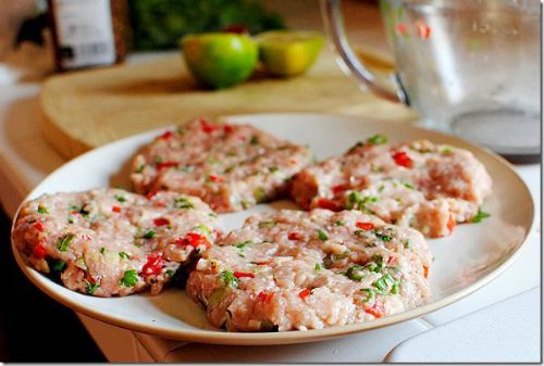 uncooked turkey burgers with red and green spices