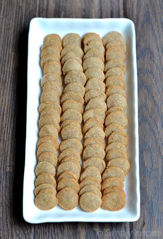 a white rectangle plate with four rows of round cheese crackers