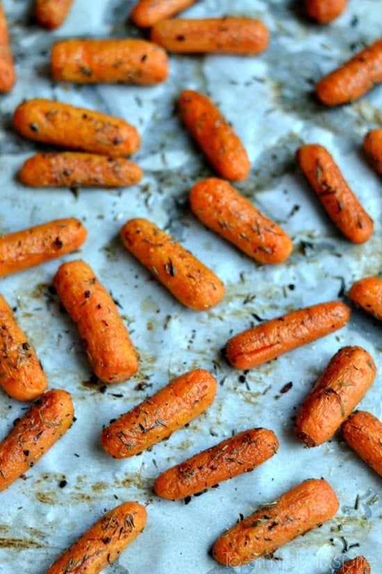 cooked baby carrots on parchment paper