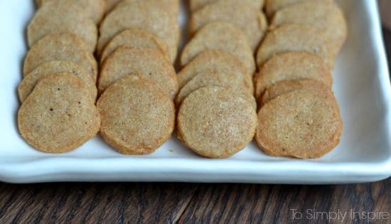 rows of round cheese crackers on a white plate