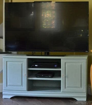 a light green TV stand with a flat screen tV