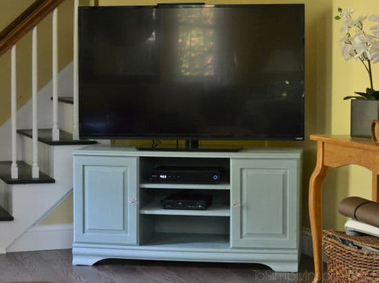 a light green TV stand with a flat screen tV