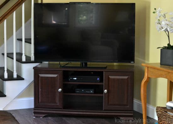 a dark wood TV stand with a flat screen tV
