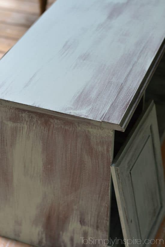 a wooden TV stand being painted