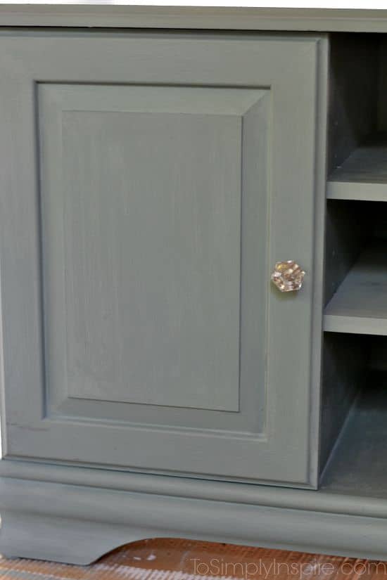 A close up of a door of a TV stand painted light green