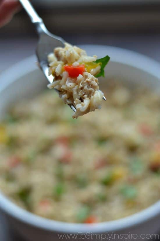 A close up of a brown rice on a fork with a red pepper