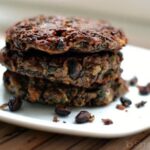 a stack of three black bean burgers on a white plate