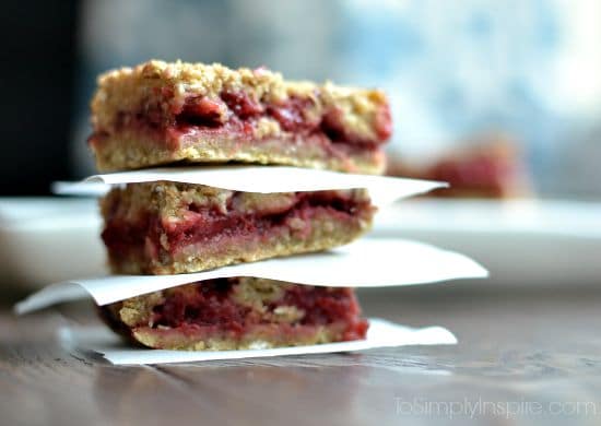 closeup of three strawberry oatmeal bars stacked with parchment paper between each one