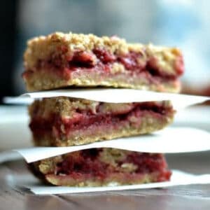 stack of three strawberry oatmeal bars separated with parchment paper