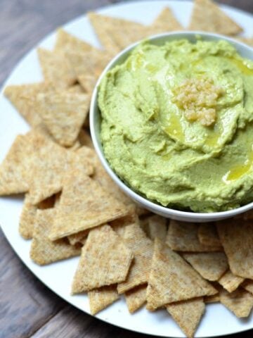 Avocado Hummus recipe on a plate with crackers.