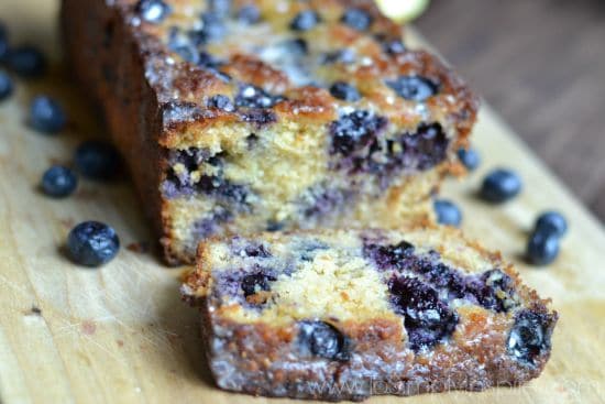 A close up of a slice of blueberry bread on a cutting board