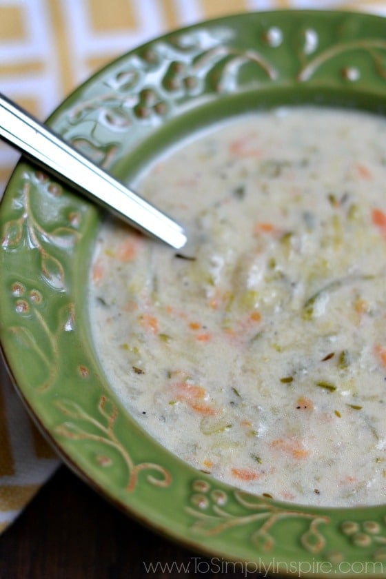 Creamy Zucchini and Carrot soup is made in just 30 minutes with no heavy cream. closeup of Soup recipe in a green bowl with a spoon