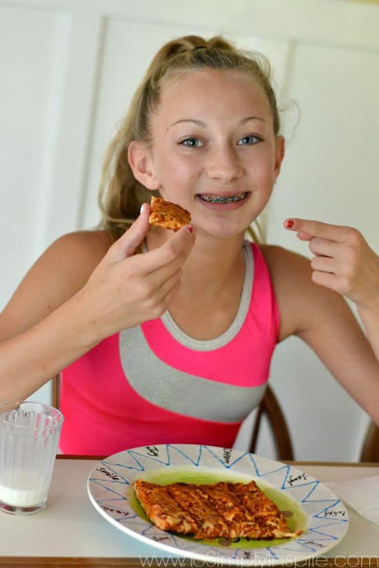 A girl eating a slice of pizza 