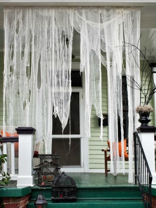 Halloween ghost drapes hanging down from front porch 