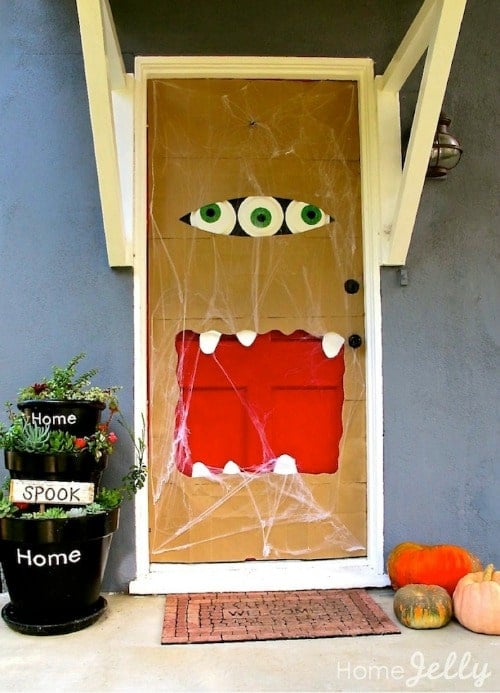 Front door decorated with a halloween paper bag monster