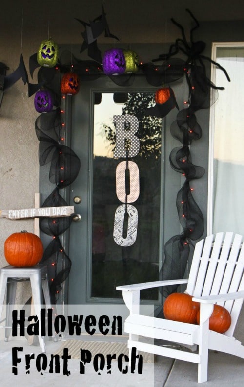 black front door with a Boo sign 