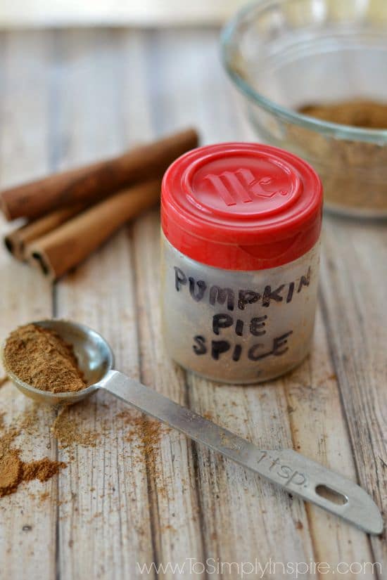 a small plastic spice container that says pumpkin spice with a silver measuring spoon