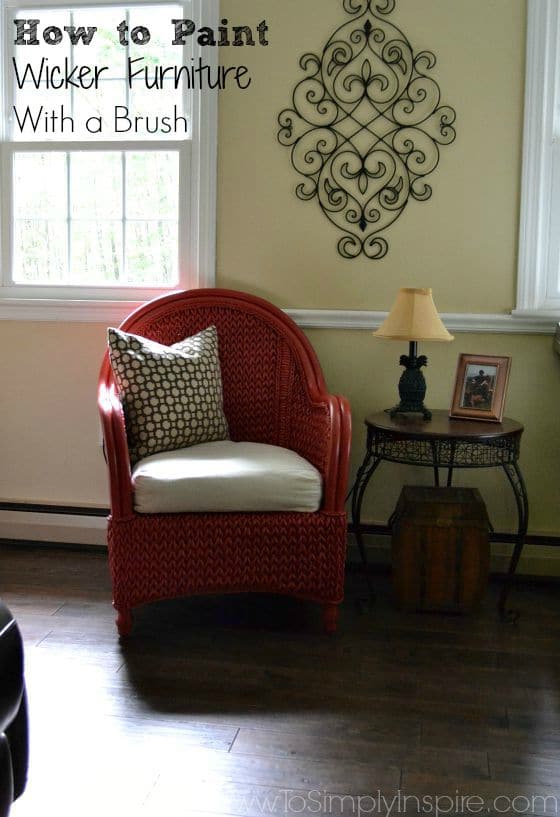 a red painted chair next to a table and lamp