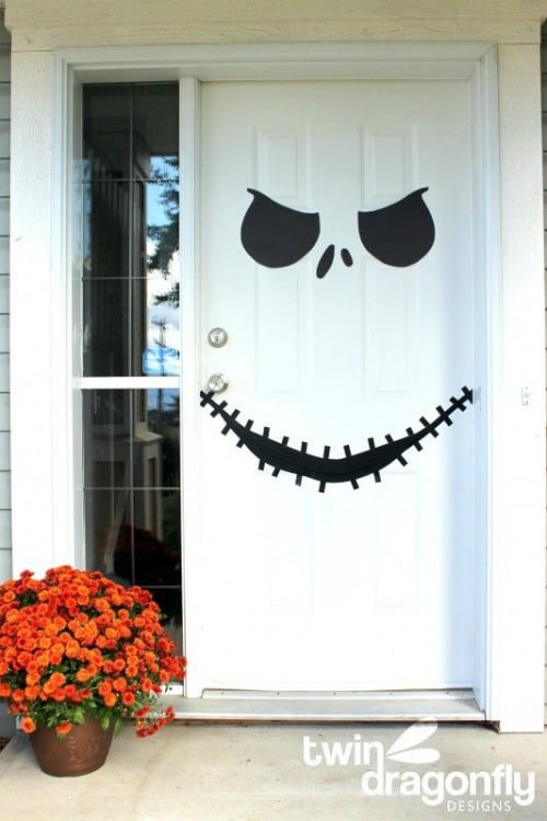 halloween front door decorated with a scary face