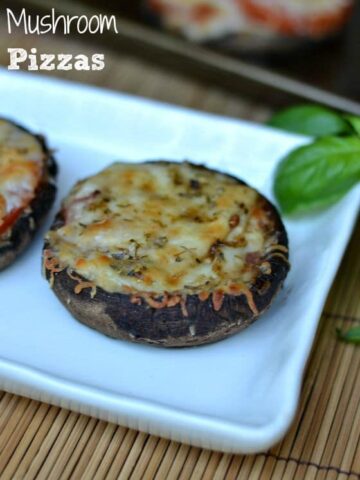 a white plate with a large portobello mushroom topped with cheese