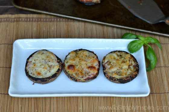a rectangle plate with three portobello mushrooms topped with cheese.