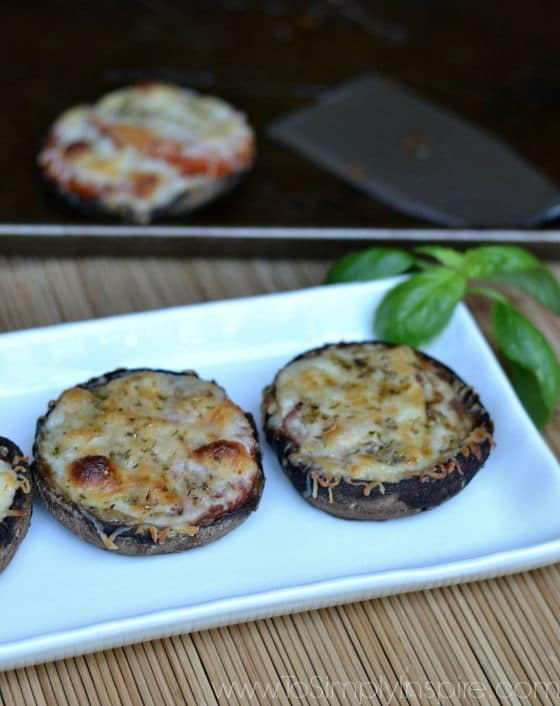 a white plate with two large portobello mushrooms topped with cheese