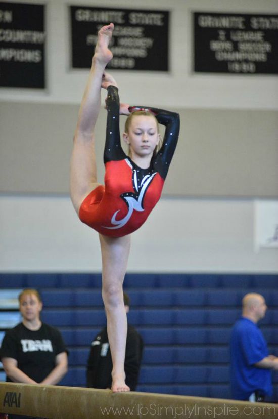 A girl balancing on a one leg while holding the other leg 