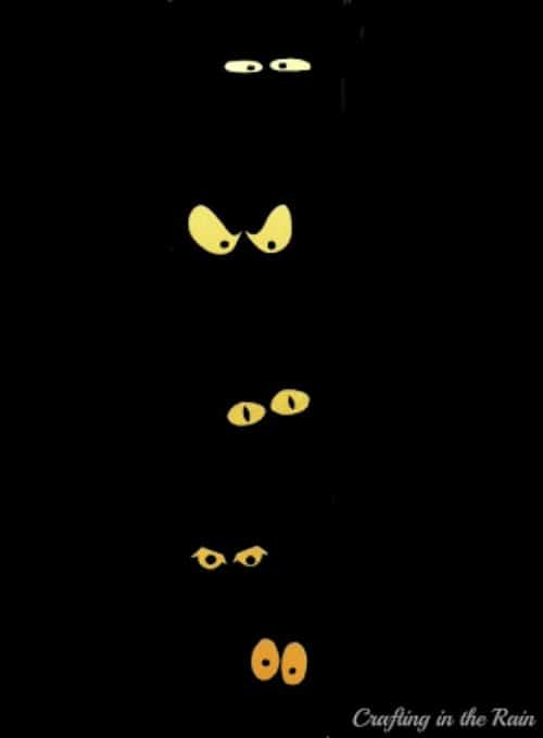 3 sets of yellow spooky eyes on a black front door