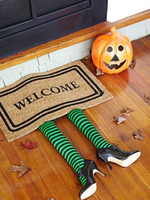 halloween door mat with witch lets under a doormat