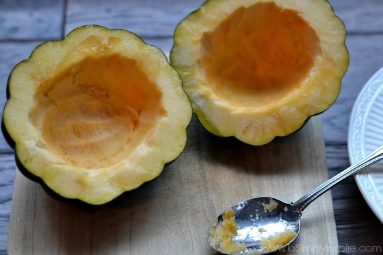 acorn squash halves scooped out on a cutting board