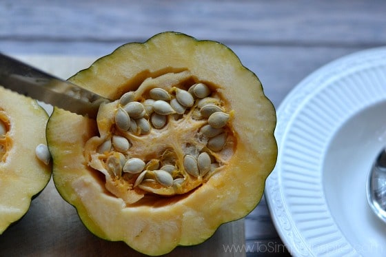 closeup of a half of acorn squash with a knife