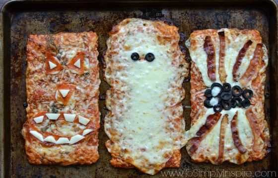 Three slices of rectangle ellios pizza made to look like a jack-o-lantern, mummy and spider