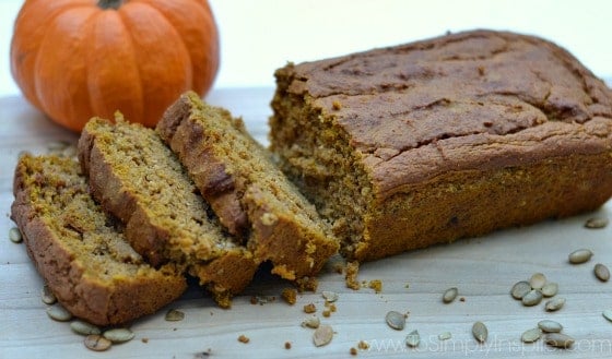 a loaf of pumpkin loaf bread with three slices cut