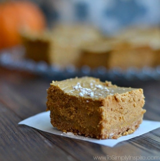 closeup of a square of pumpkin cheesecake  on a wood table