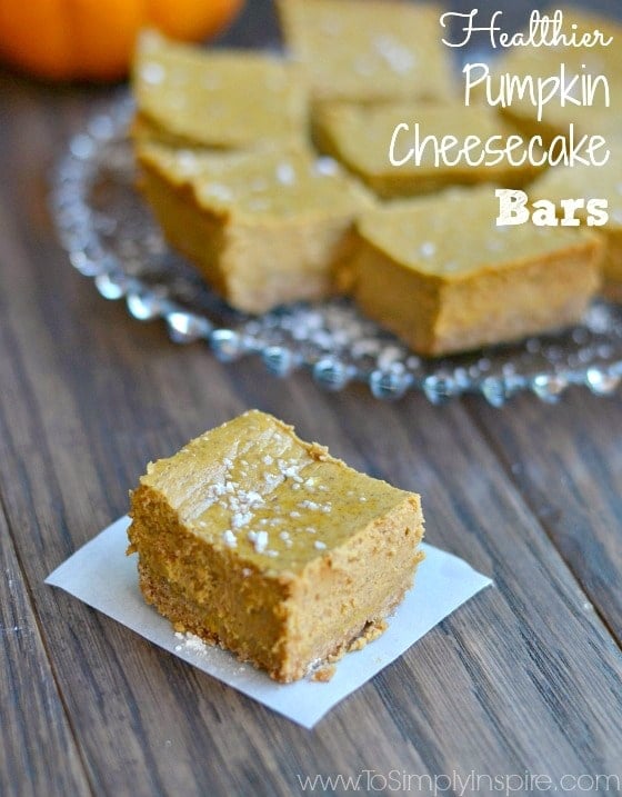 A pumpkin cheesecake bar on a white napkin with  plateful in the background