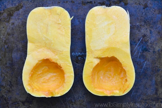 two halves of a butternut squash on a baking dish